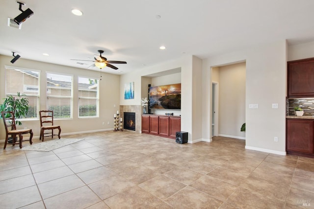 living room featuring light tile patterned floors, a ceiling fan, visible vents, and a tiled fireplace