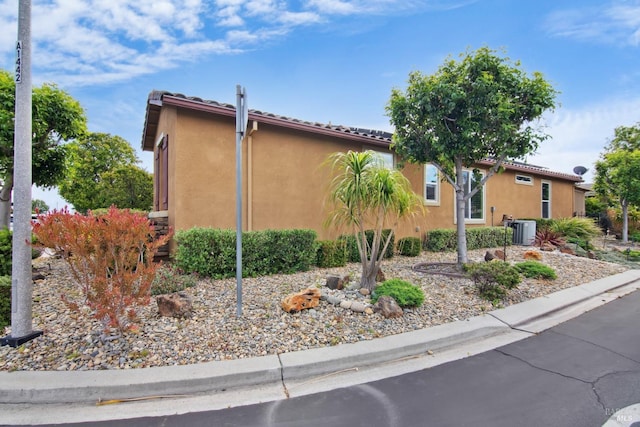 view of home's exterior with central air condition unit and stucco siding
