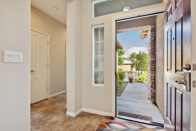 foyer featuring baseboards and light tile patterned flooring