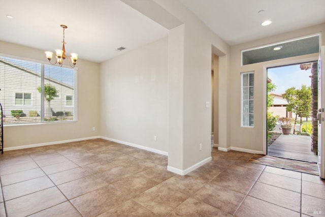 entrance foyer featuring an inviting chandelier, light tile patterned flooring, visible vents, and baseboards
