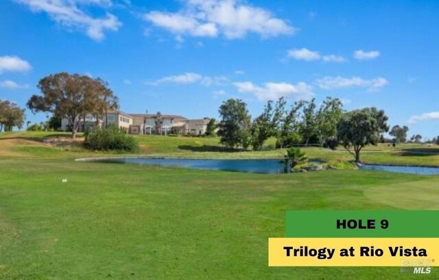 view of property's community featuring golf course view, a water view, and a lawn