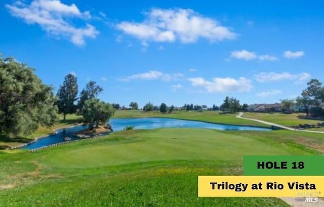 view of community featuring view of golf course, a water view, and a yard