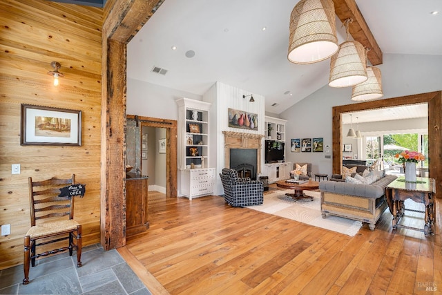 5310 Silverado Trl, Napa, CA 94558 - living area featuring a fireplace, high vaulted ceiling, wood walls, light wood-style flooring, and visible vents