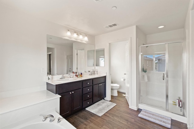 full bathroom featuring double vanity, toilet, visible vents, and a shower stall