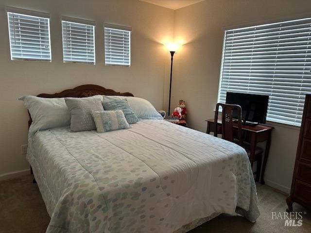 bedroom featuring light colored carpet and baseboards