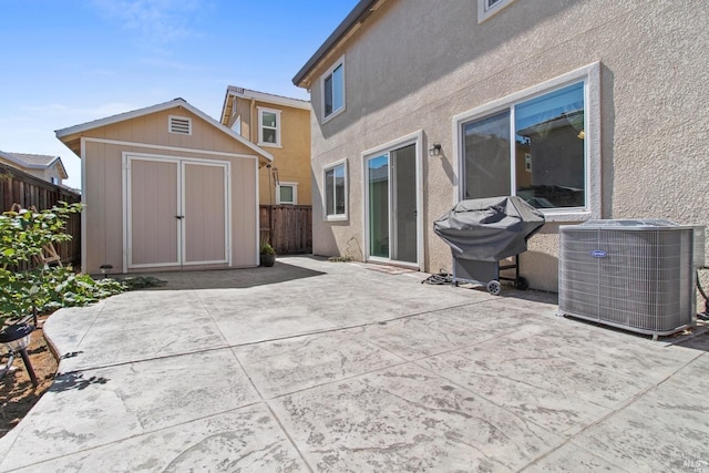 rear view of house with an outdoor structure, cooling unit, a patio area, a storage shed, and a fenced backyard