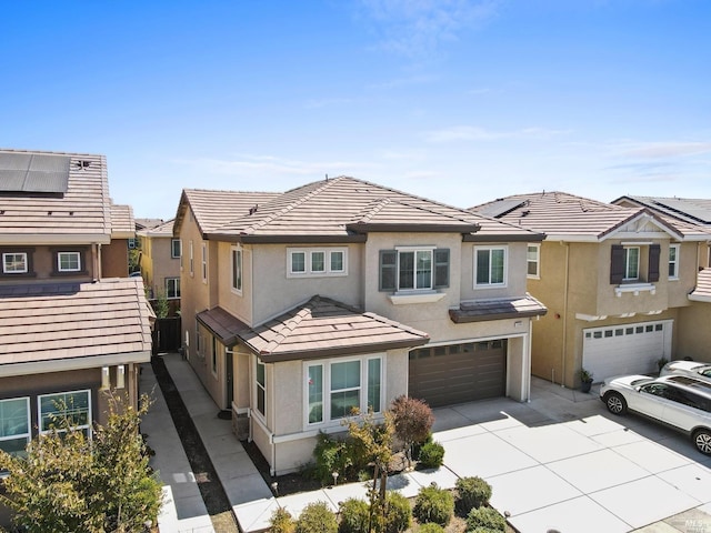 townhome / multi-family property with stucco siding, a tiled roof, a garage, a residential view, and concrete driveway