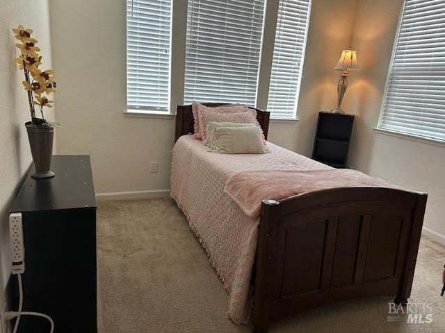 bedroom with baseboards and light carpet