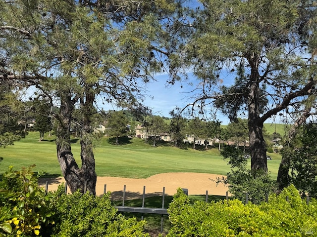 view of home's community with a lawn and view of golf course