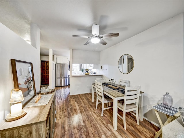 dining area featuring baseboards, wood finished floors, and ceiling fan