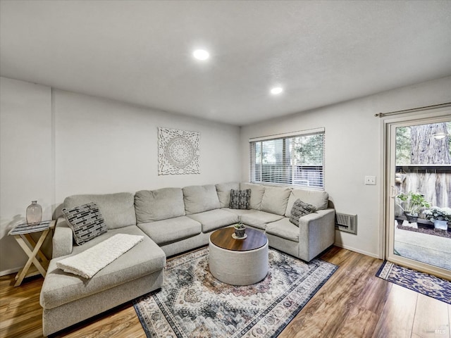 living room featuring wood finished floors, recessed lighting, and baseboards