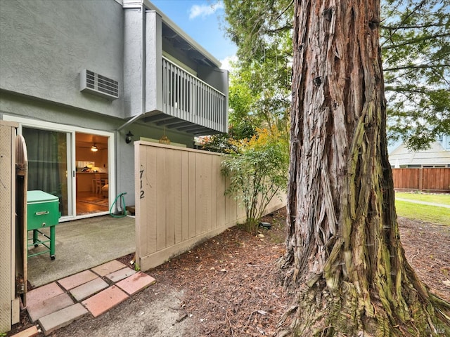 view of yard featuring fence and a balcony