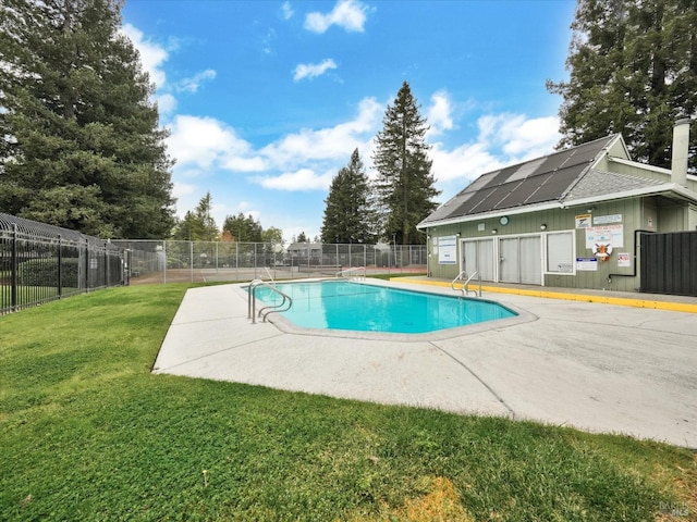 pool with a lawn, fence, and a patio