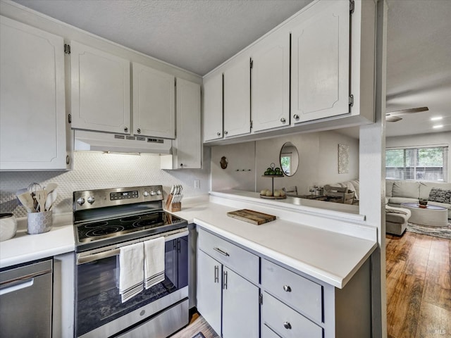 kitchen with stainless steel appliances, under cabinet range hood, light wood-style flooring, light countertops, and white cabinets