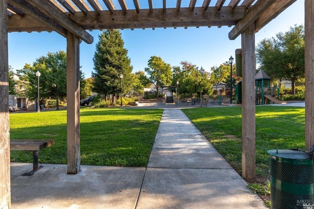 view of property's community with a lawn, playground community, and a pergola