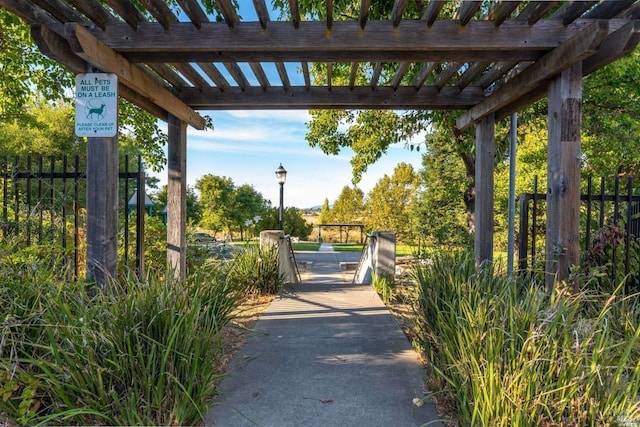 view of community featuring fence and a pergola