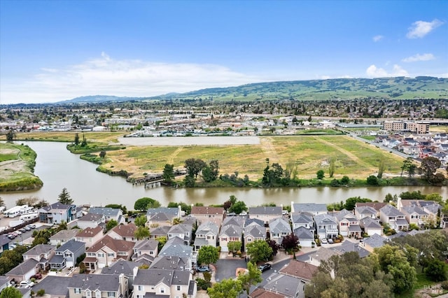 drone / aerial view with a water and mountain view and a residential view