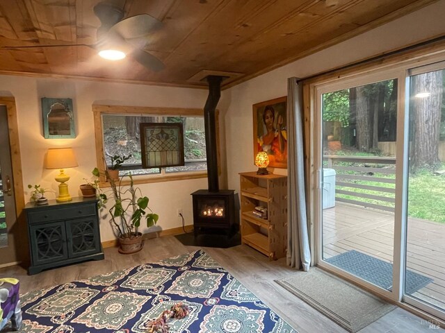 living area featuring baseboards, wood ceiling, and ceiling fan
