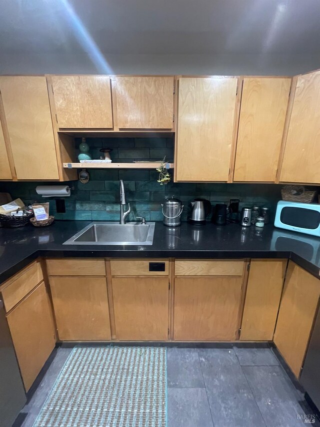 kitchen with dark countertops, appliances with stainless steel finishes, a peninsula, baseboards, and backsplash