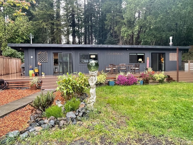 back of house with a lawn and a deck