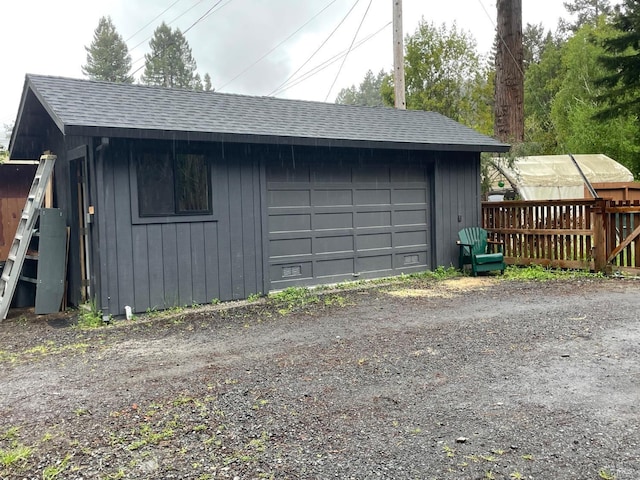 detached garage featuring fence