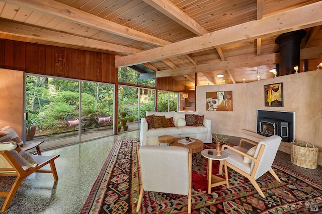living room featuring a wood stove, vaulted ceiling with beams, and wood ceiling
