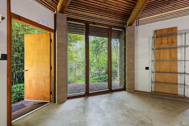 doorway with plenty of natural light and unfinished concrete flooring