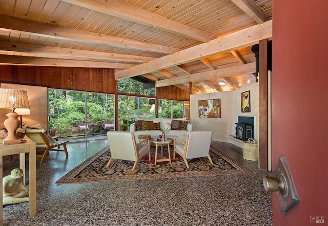 dining area featuring a wood stove, lofted ceiling with beams, speckled floor, and wood ceiling