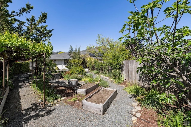 view of yard with fence and a garden