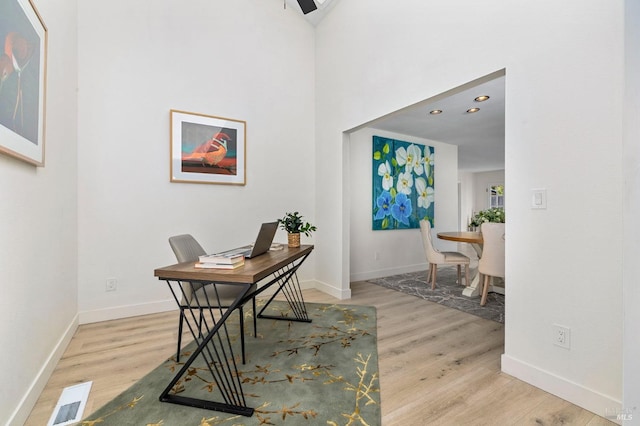 office with baseboards, visible vents, and light wood-style flooring
