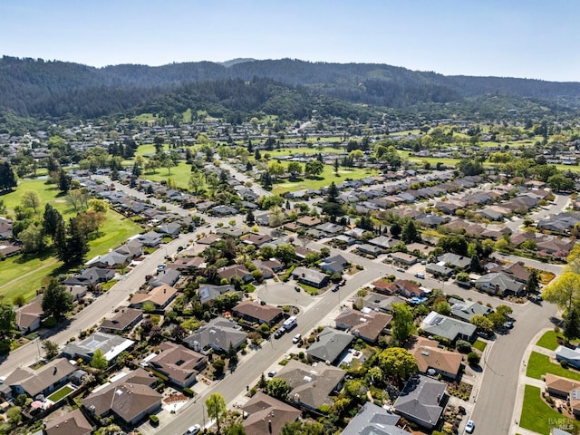 birds eye view of property featuring a residential view, a mountain view, and a wooded view