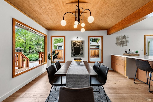dining room with crown molding, baseboards, an inviting chandelier, and light wood-style floors