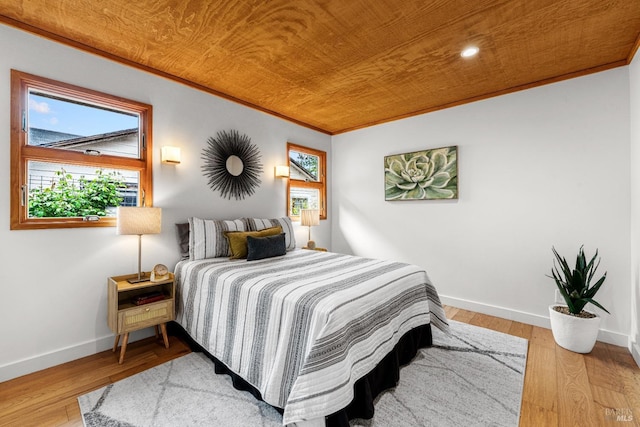 bedroom with baseboards, wood-type flooring, and crown molding