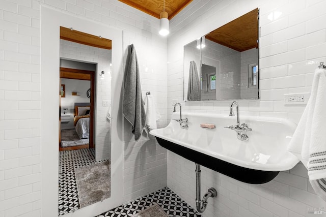 ensuite bathroom featuring ensuite bath and tile walls
