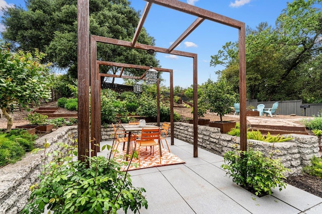 view of patio with fence, outdoor dining space, and a pergola
