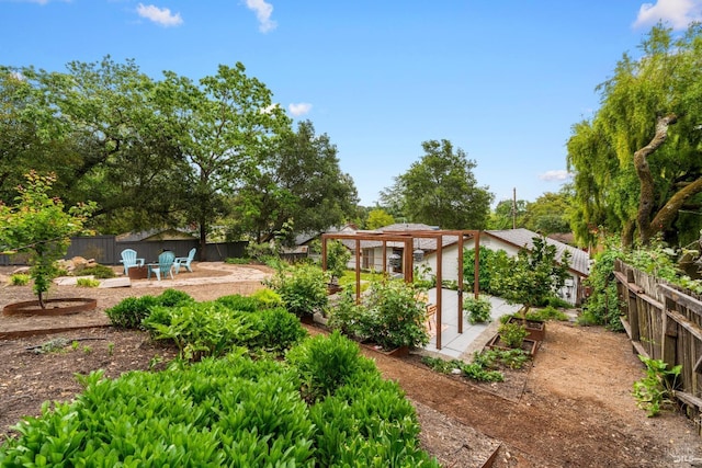 view of yard featuring a fenced backyard, a patio, a pergola, and a vegetable garden