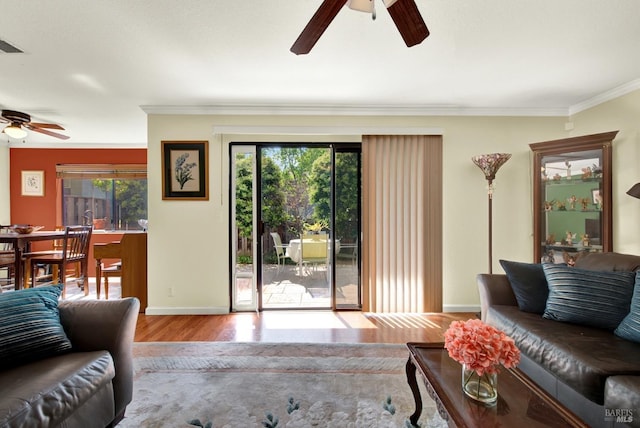 living room with crown molding, ceiling fan, wood finished floors, and a wealth of natural light