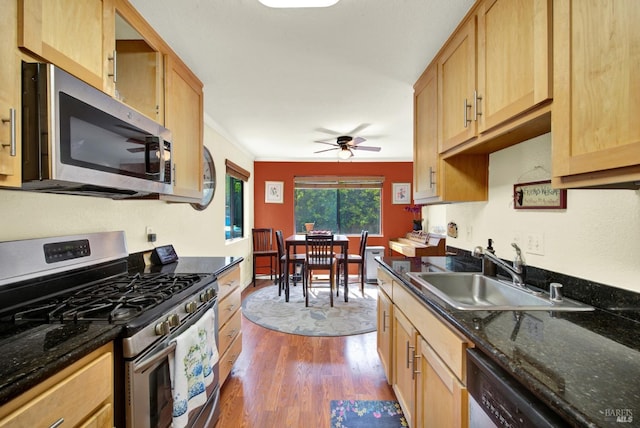 kitchen featuring a ceiling fan, light brown cabinetry, dark wood finished floors, a sink, and stainless steel appliances