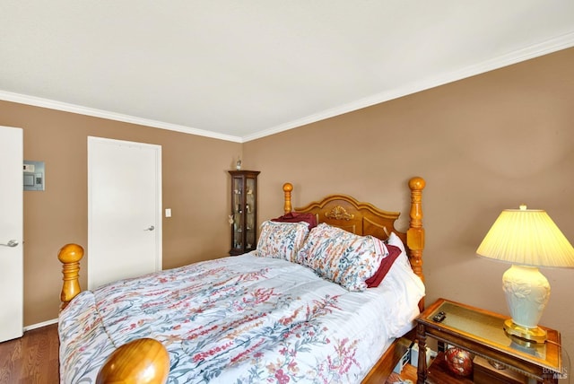 bedroom featuring baseboards, ornamental molding, and wood finished floors