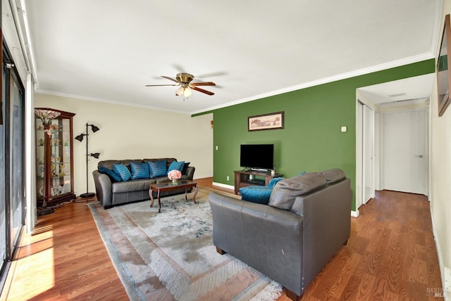 living room with baseboards, a ceiling fan, wood finished floors, and ornamental molding