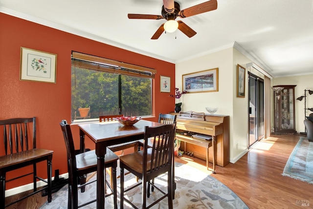 dining space featuring baseboards, ornamental molding, a ceiling fan, and wood finished floors