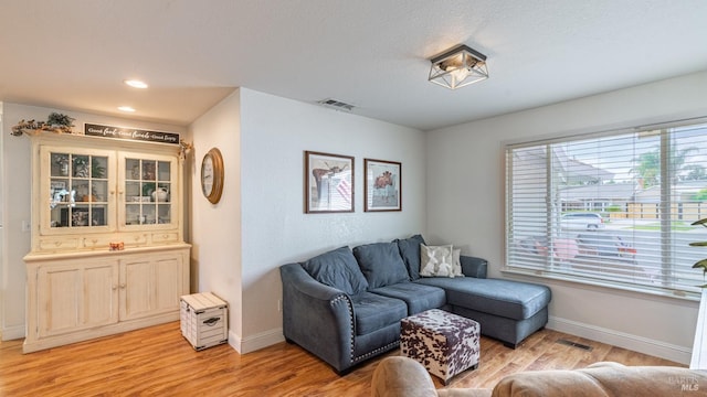 living room featuring baseboards, visible vents, and light wood-style floors