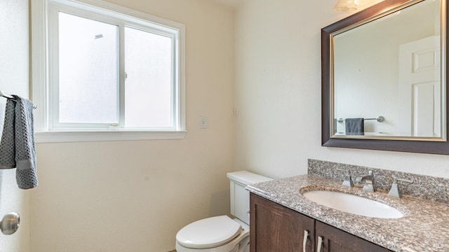 bathroom featuring a healthy amount of sunlight, toilet, and vanity
