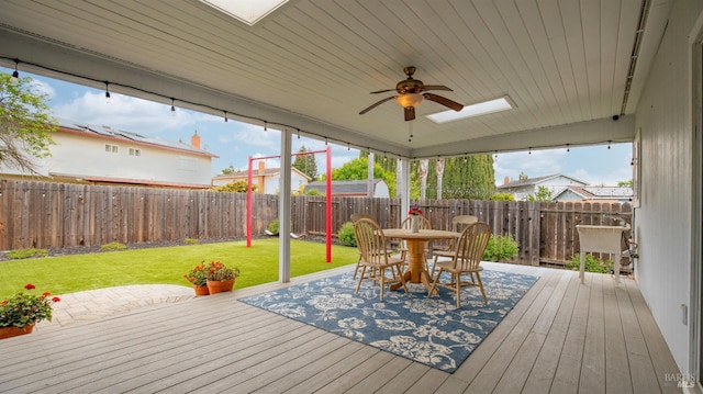 wooden deck featuring a fenced backyard, a ceiling fan, outdoor dining area, and a yard