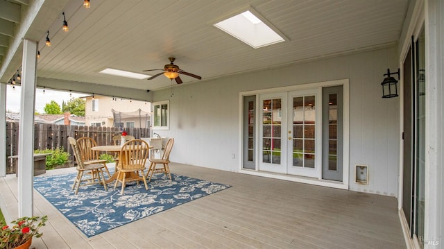 wooden deck with outdoor dining area, ceiling fan, french doors, and fence
