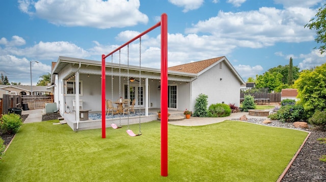 back of property featuring a patio area, ceiling fan, a yard, french doors, and a fenced backyard