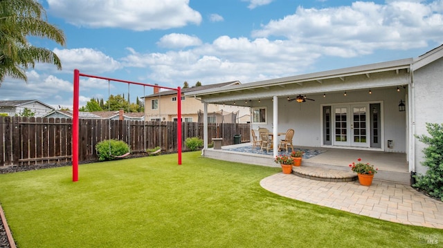 view of yard featuring ceiling fan, french doors, a fenced backyard, and a patio area
