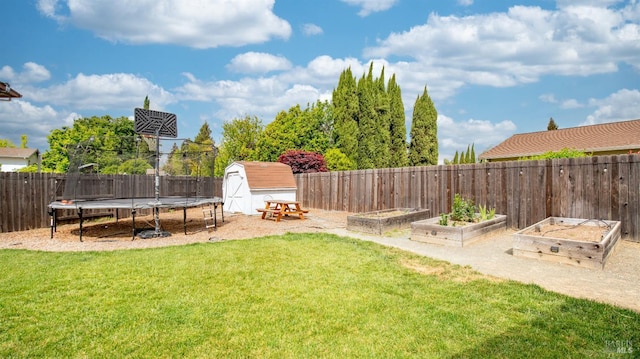 view of yard featuring a garden, a trampoline, an outbuilding, a fenced backyard, and a shed