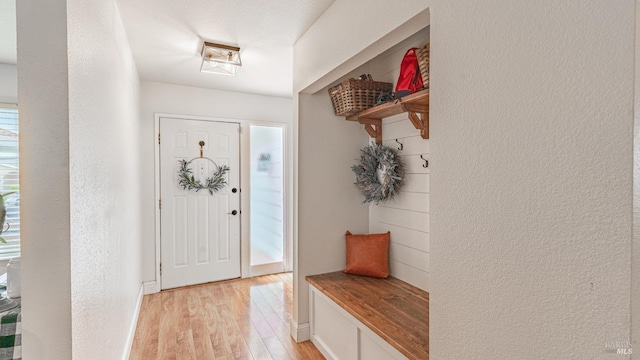 mudroom featuring light wood-style floors and a textured wall