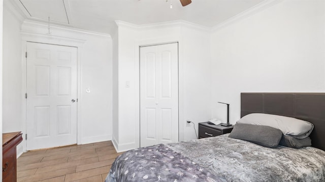 bedroom featuring crown molding, ceiling fan, a closet, attic access, and wood finished floors